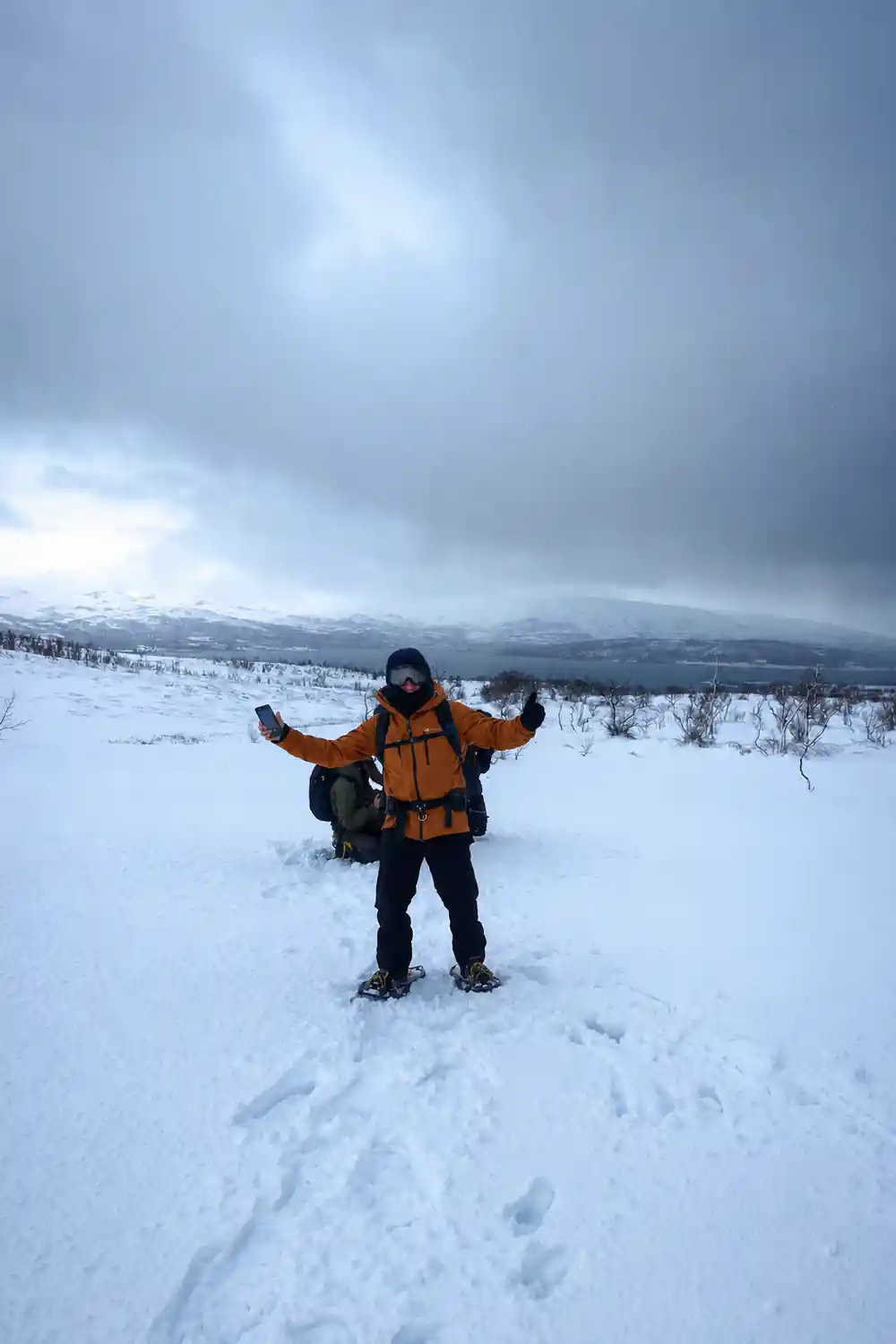 A visitor standing arms out in deep untracked snow